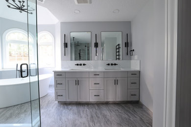 Freestanding bathtub - master double-sink freestanding bathtub idea in Portland with shaker cabinets, gray cabinets, a bidet, quartz countertops, a hinged shower door and a freestanding vanity