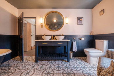 Example of a mid-sized classic kids' porcelain tile porcelain tile, blue floor and double-sink freestanding bathtub design in Other with flat-panel cabinets, blue cabinets, a one-piece toilet, beige walls, quartzite countertops, a hinged shower door, white countertops and a freestanding vanity