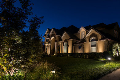 Mid-sized tuscan beige three-story stucco gable roof photo in Other