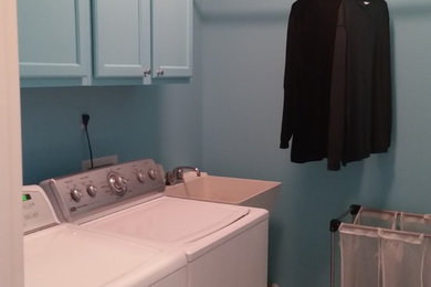Inspiration for a mid-sized traditional single-wall dedicated laundry room in DC Metro with an utility sink, recessed-panel cabinets, blue cabinets, blue walls, vinyl floors and beige floor.