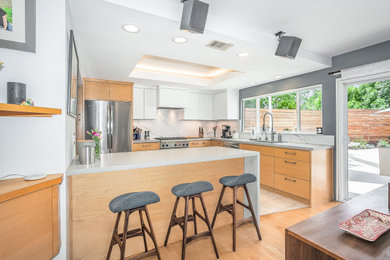 Example of a trendy kitchen design in Los Angeles with a single-bowl sink, flat-panel cabinets, light wood cabinets, quartz countertops, quartz backsplash and stainless steel appliances