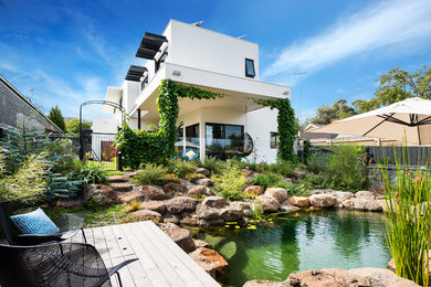 Photo of a mid-sized contemporary two-storey concrete white exterior in Melbourne with a flat roof.