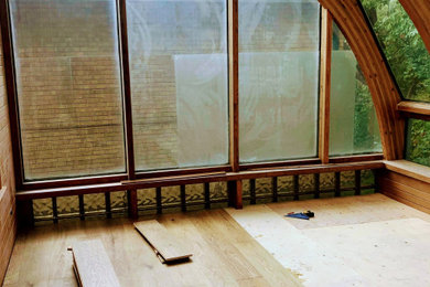 Diseño de galería actual grande con suelo de madera en tonos medios, techo de vidrio y suelo marrón