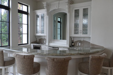 Elegant u-shaped seated home bar photo in Columbus with glass-front cabinets, white cabinets, granite countertops, multicolored backsplash and stone slab backsplash