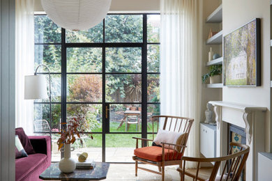 Mittelgroßes Modernes Wohnzimmer mit beiger Wandfarbe, hellem Holzboden, Kamin, Kaminumrandung aus Holz, TV-Wand und braunem Boden in London
