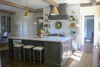 Inspiration for a medium tone wood floor eat-in kitchen remodel in Austin with a farmhouse sink, gray cabinets, white backsplash, subway tile backsplash, stainless steel appliances and an island