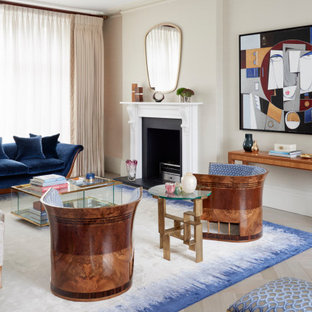 Photo of a large traditional formal enclosed living room in London with beige walls, medium hardwood flooring, a standard fireplace, a stone fireplace surround, no tv, multi-coloured floors and wallpapered walls.