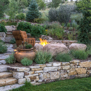 Inspiration for a large bohemian back xeriscape partial sun garden for spring in Denver with a fire feature and natural stone paving.