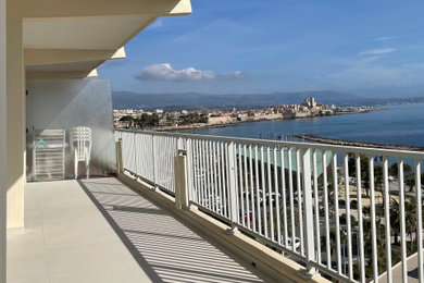 Idées déco pour un grand balcon bord de mer d'appartement avec une extension de toiture.