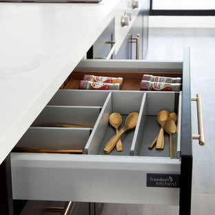 Idée de décoration pour une grande arrière-cuisine parallèle design avec un évier 1 bac, un placard à porte shaker, des portes de placard jaunes, un plan de travail en quartz modifié, une crédence jaune, une crédence en dalle de pierre, un électroménager en acier inoxydable, un sol en bois brun et un îlot central.