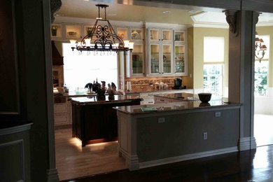Example of a large transitional l-shaped marble floor open concept kitchen design in Dallas with a double-bowl sink, glass-front cabinets, distressed cabinets, granite countertops, multicolored backsplash, subway tile backsplash, stainless steel appliances and an island