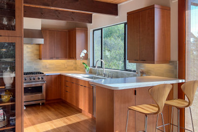 Inspiration for a mid-sized modern eat-in kitchen in San Francisco with an undermount sink, flat-panel cabinets, medium wood cabinets, quartz benchtops, green splashback, ceramic splashback, stainless steel appliances, medium hardwood floors, no island, white benchtop and exposed beam.