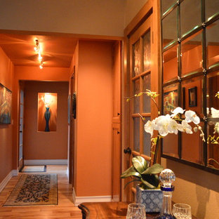 Foto på en liten vintage hall, med orange väggar, ljust trägolv och orange golv