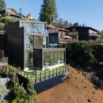 Three-level exterior with dark steel cladding, rooftop deck - Fold House