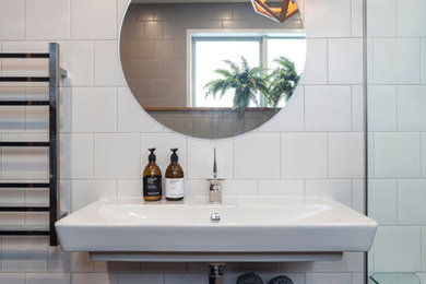 Photo of a mid-sized contemporary master bathroom in Melbourne with open cabinets, medium wood cabinets, white tile, subway tile, porcelain floors, a wall-mount sink and wood benchtops.