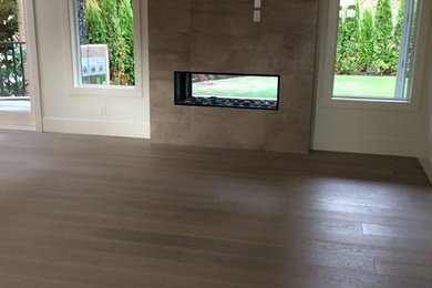 This is an example of a mid-sized modern formal open concept living room in Vancouver with white walls, dark hardwood floors, a two-sided fireplace, a concrete fireplace surround, no tv and brown floor.