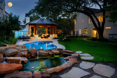 This is an example of a modern full sun backyard pond in Houston.
