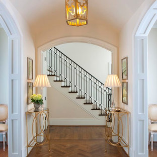 Idéer för en klassisk hall, med vita väggar, mellanmörkt trägolv och brunt golv