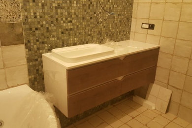 Пример оригинального дизайна: ванная комната среднего размера в современном стиле с светлыми деревянными фасадами, мраморной столешницей и белой столешницей