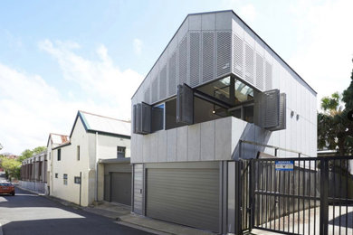 Inspiration for a small modern grey exterior in Sydney with concrete fiberboard siding and a metal roof.