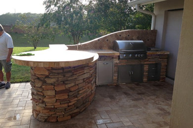 Design ideas for a mid-sized traditional backyard patio in Tampa with an outdoor kitchen, brick pavers and no cover.