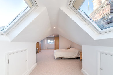 Inspiration for a mid-sized contemporary master bedroom in London with white walls, carpet and beige floor.