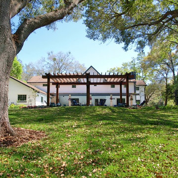 Backyard Tudor revival landscape along a natural area with a stream