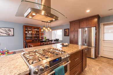 Open concept kitchen - large transitional galley ceramic tile open concept kitchen idea in San Diego with flat-panel cabinets, a peninsula, an undermount sink, medium tone wood cabinets, granite countertops, beige backsplash, glass tile backsplash and stainless steel appliances