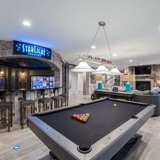 Imagen de sótano clásico, de tamaño medio, con paredes grises, suelo de baldosas de cerámica, chimenea tradicional, marco de chimenea de piedra y suelo beige