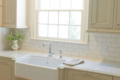 Example of a transitional medium tone wood floor kitchen design in Atlanta with a farmhouse sink, beige cabinets, quartzite countertops and an island