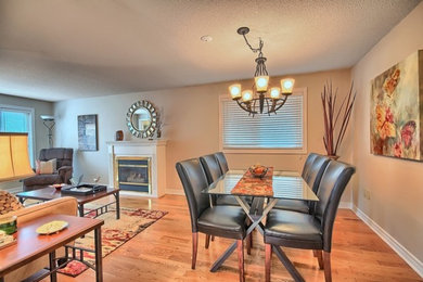 Inspiration for a contemporary light wood floor dining room remodel in Toronto with a standard fireplace