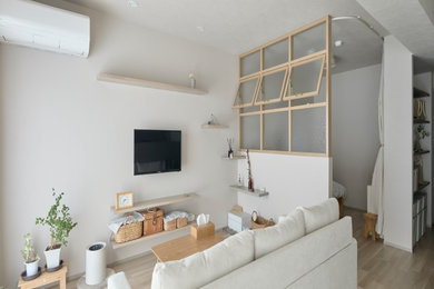 名古屋にある北欧スタイルのおしゃれなリビング (ベージュの壁、壁掛け型テレビ、茶色い床、ベージュの天井) の写真