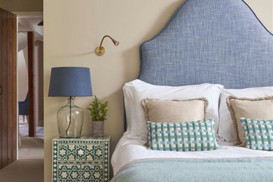 This is an example of a traditional master bedroom in Kent with beige walls.