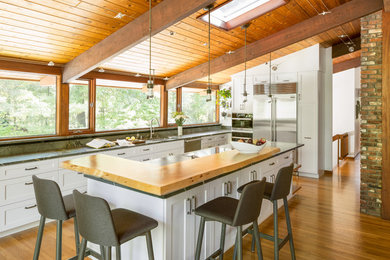 Large midcentury galley eat-in kitchen in Boston with an undermount sink, shaker cabinets, white cabinets, soapstone benchtops, stainless steel appliances, light hardwood floors and with island.