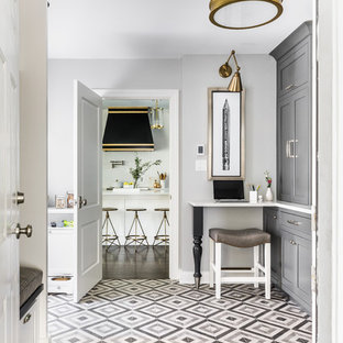 Cette image montre une entrée bohème de taille moyenne avec un vestiaire, un mur gris, un sol en carrelage de porcelaine et un sol multicolore.