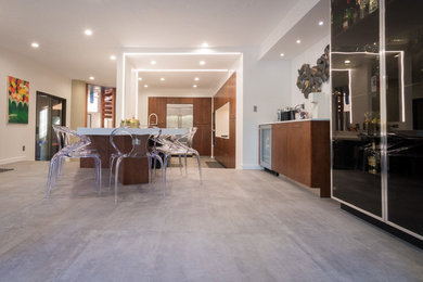 Large danish l-shaped porcelain tile and gray floor eat-in kitchen photo in Los Angeles with an undermount sink, flat-panel cabinets, medium tone wood cabinets, quartz countertops, white backsplash, stone slab backsplash, stainless steel appliances and an island