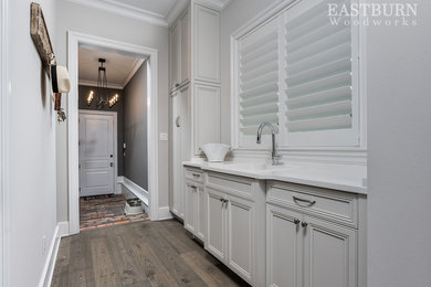 Inspiration for a light wood floor utility room remodel in Other with a drop-in sink, white cabinets, marble countertops and white walls