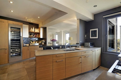 Minimalist galley eat-in kitchen photo in Seattle with an undermount sink, flat-panel cabinets, medium tone wood cabinets, quartzite countertops, black backsplash and stainless steel appliances