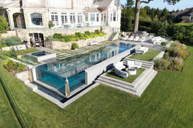 Photo of a large modern backyard rectangular infinity pool in New York with a hot tub.