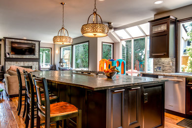 Example of a mid-sized minimalist u-shaped light wood floor eat-in kitchen design in Seattle with recessed-panel cabinets, dark wood cabinets, granite countertops, gray backsplash, ceramic backsplash, stainless steel appliances and an island