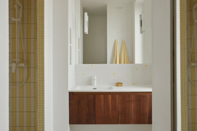 Idée de décoration pour une douche en alcôve principale design de taille moyenne avec des portes de placard marrons, un carrelage jaune, des carreaux de céramique, un mur jaune, un sol en carrelage de terre cuite, un lavabo encastré, un sol blanc, aucune cabine, un plan de toilette blanc, buanderie, meuble simple vasque et meuble-lavabo encastré.