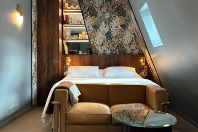 Cette photo montre une petite chambre parentale tendance avec un mur bleu, sol en béton ciré, aucune cheminée, un sol beige et du papier peint.