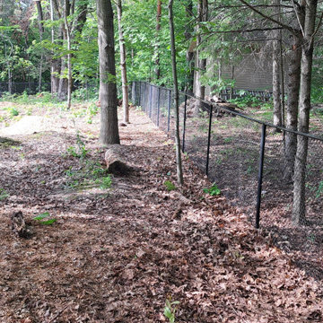 Black Chain-Link Fence Installation in a Wooded Area