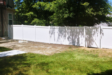 ワシントンD.C.にある広いトラディショナルスタイルのおしゃれな裏庭 (樹脂フェンス) の写真