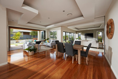 This is an example of a large contemporary kitchen/dining combo in Sydney with beige walls and medium hardwood floors.