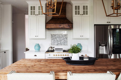 Inspiration for a large country l-shaped medium tone wood floor kitchen remodel in Indianapolis with shaker cabinets, white cabinets, quartz countertops, white backsplash, ceramic backsplash, stainless steel appliances and white countertops