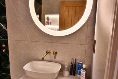 Medium sized modern shower room bathroom in Surrey with flat-panel cabinets, brown cabinets, a built-in shower, a wall mounted toilet, white tiles, ceramic tiles, white walls, ceramic flooring, a built-in sink, granite worktops, white floors, a sliding door, white worktops, a single sink and a floating vanity unit.