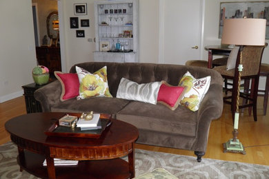 Example of a large classic open concept medium tone wood floor living room design in Charlotte with white walls