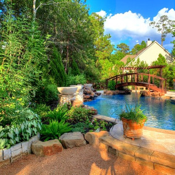 Natural Pool with rock waterfall, bridge, spa, and pergola