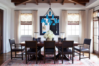 Beach style dining room in Los Angeles with white walls and dark hardwood floors.